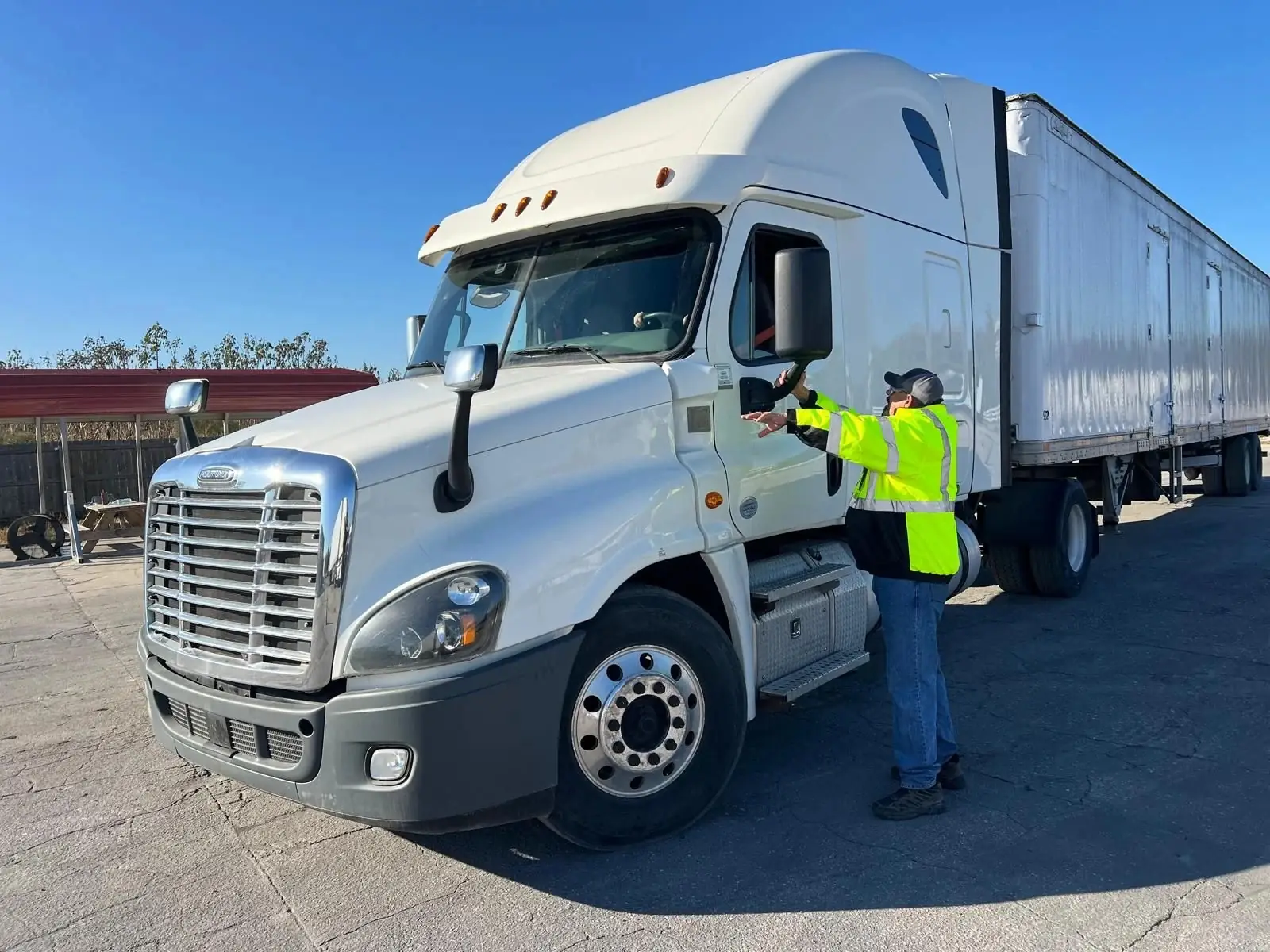 Instructor beside a white semi truck and trailer on the Tampa training lot